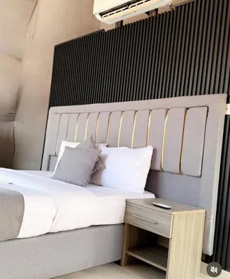 a bed with white sheets and pillows next to a table at RUM NADINE LUXURY CAMP & Bubbles Hotel in Wadi Rum