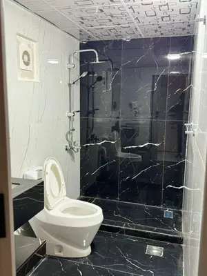 a bathroom with a toilet and a black tiled shower at Sunrise Echo Camp in Wadi Rum