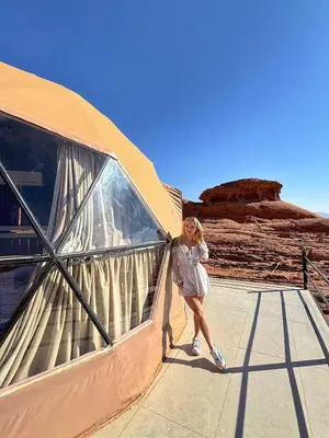a woman walking on a walkway in the desert at Sunrise Echo Camp in Wadi Rum
