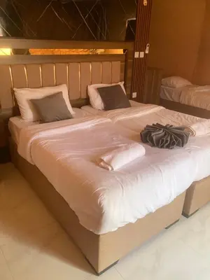 a large bed with white sheets and pillows at Sunrise Echo Camp in Wadi Rum