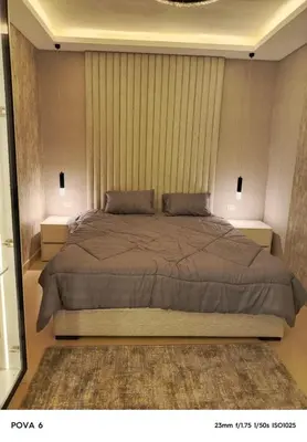 a bedroom with a large bed with two night stands at Al yaqoot apartment in Amman