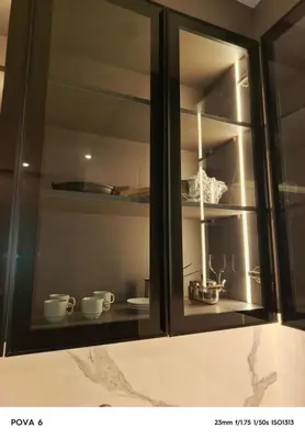 a glass cabinet with cups and dishes in it at Al yaqoot apartment in Amman