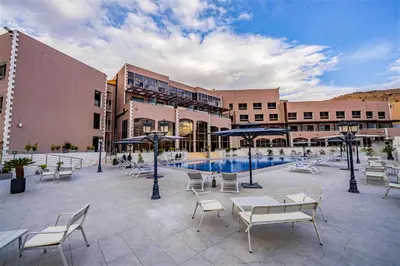 a courtyard with chairs and a pool in a building at Petra Pillars Luxury Hotel in Petra