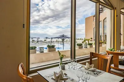 a dining room with a table with a view of a pool at Petra Pillars Luxury Hotel in Petra