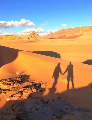 two people walking in the desert holding hands at ELENA lUXURY CAMP in Wadi Rum