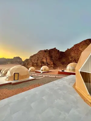 a group of tents in the desert with mountains at ELENA lUXURY CAMP in Wadi Rum