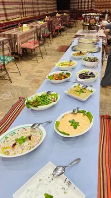 a long blue table with plates of food on it at Desert Nights camp in Aqaba
