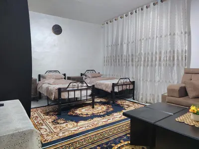 two twin beds in a living room with a couch at small house in Amman