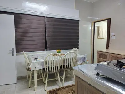a kitchen with a table and chairs and a kitchen with a refrigerator at small house in Amman