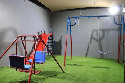 a play room with a swing set and a swing at Bellagio Chaleht in Al Rama
