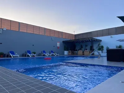 a large swimming pool with chairs in a building at Bellagio Chaleht in Al Rama