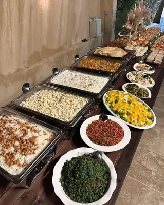 a table with many trays of different types of food at Le Shot tours Hotel in Al Jafr