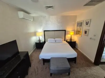 a bedroom with a bed and a flat screen tv at Le Shot tours Hotel in Al Jafr