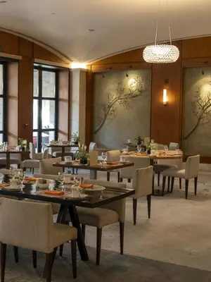 a dining room with tables and chairs and a chandelier at Le Shot tours Hotel in Al Jafr