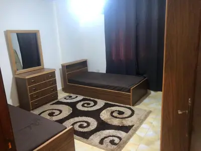 a bedroom with a bed and a dresser and a mirror at Irbid in Irbid