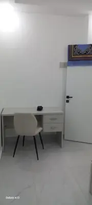 an office with a desk and a chair and a refrigerator at غزو 15 in Irbid