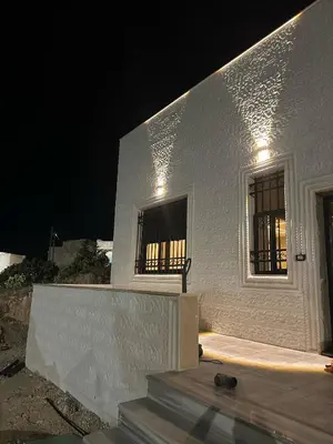 a white building with a window at night at Luxury Haven villa in Jerash
