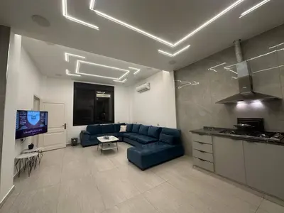 a living room with a blue couch and a tv at Luxury Haven villa in Jerash