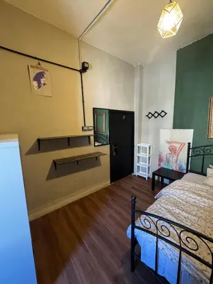 a bedroom with a bed and a desk in it at Cozy Studio in a Creative Hub in Amman