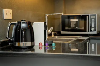 a coffee pot on a counter next to a microwave at Maria Suites 2 in Aqaba