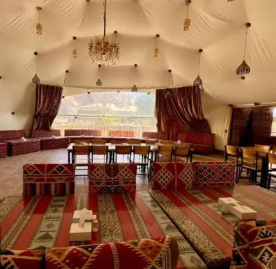 a room with a tent with a table and chairs at Wadi Rum, the best stars in Wadi Rum