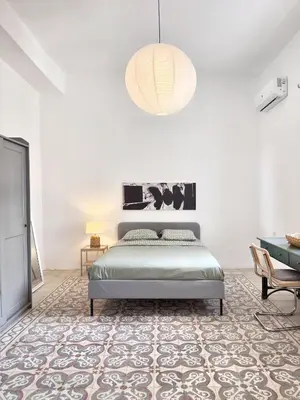 a bedroom with a bed and a pendant light at Turath by Badiya 2BR Apt In Luweibdeh in Amman