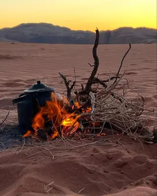 a campfire in the desert with a pot on it at Desert Time in Wadi Rum