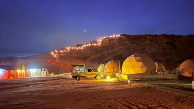 a truck parked next to domes and a mountain at night at HAGIA SOPHIA lUXURY CAMP in Disah
