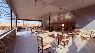 a restaurant with tables and chairs and windows at HAGIA SOPHIA lUXURY CAMP in Disah