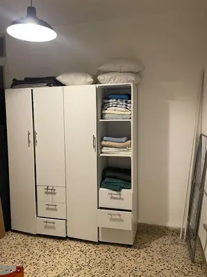 a white closet with white cabinets and towels at Central apartment with beautiful view in Amman