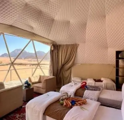 a room with three beds in a room with a window at Wadi Rum Salem in Wadi Rum
