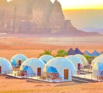 a group of tents in the desert with a mountain in the background at Wadi Rum Salem in Wadi Rum