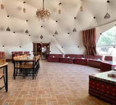 a large room with tables and chairs and a chandelier at Wadi Rum Salem in Wadi Rum