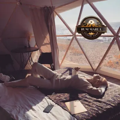 a woman laying on a bed in a tent at RUM MAREA lUXURY CAMP in Wadi Rum