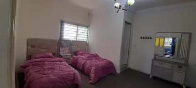two beds in a bedroom with pink blankets at Two Palms Housing in Jerash
