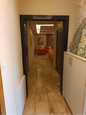 a hallway leading to a living room with an orange couch at روف طابق ثاني تشطيب فندقي باطلاله ساحرة بعمارة عائلات بعبدون الشمالي in Amman