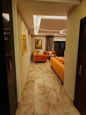 a living room with two orange couches in a room at روف طابق ثاني تشطيب فندقي باطلاله ساحرة بعمارة عائلات بعبدون الشمالي in Amman