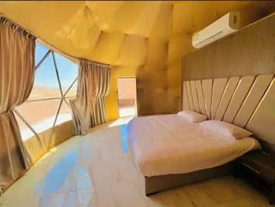 a bedroom with a bed and a large window at Wadi Rum Karolina Bubbles camp in Wadi Rum