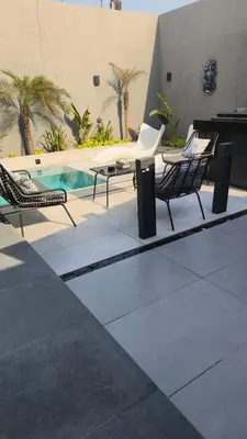 two chairs and a table next to a swimming pool at Deep House Villas in Al Rama