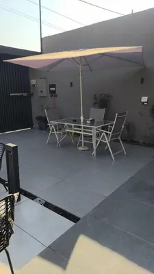 a patio with a table and chairs and an umbrella at Deep House Villas in Al Rama