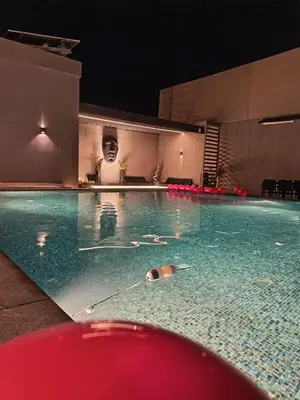 a swimming pool at night in a building at Deep House Villas in Al Rama