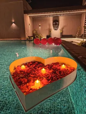 a heart shaped bathtub with candles in a swimming pool at Deep House Villas in Al Rama