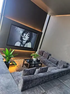 a living room with a couch and a tv at Deep House Villas in Al Rama