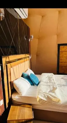 a bed with two blue pillows on top of it at Camb wadi Rum in Disah