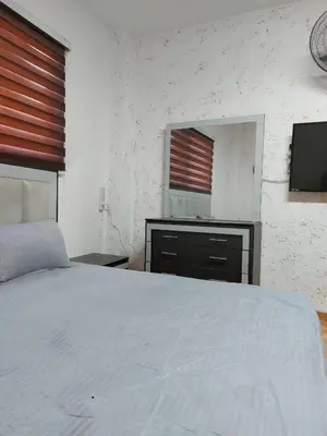 a bedroom with a white bed and a mirror at Small huose in Amman