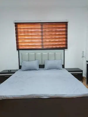 a large bed with two pillows in a bedroom at Small huose in Amman