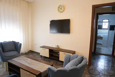 a living room with two chairs and a tv at المتطورة للشقق الفندقية in Amman