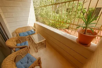 a balcony with chairs and a window with a plant at Family Deluxe Apartment in Amman
