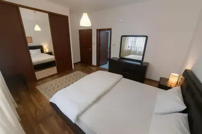 a bedroom with a large white bed and a mirror at Family Deluxe Apartment in Amman