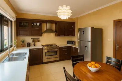 a kitchen with a table with a bowl of fruit on it at Family Deluxe Apartment in Amman